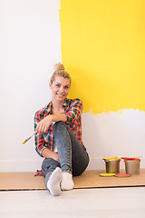 Image showing young female painter sitting on floor