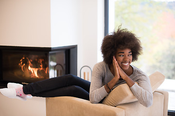 Image showing black woman in front of fireplace