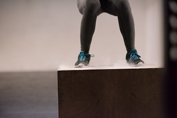 Image showing black woman is performing box jumps at gym