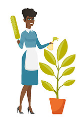 Image showing African housemaid watering the flower with spray.