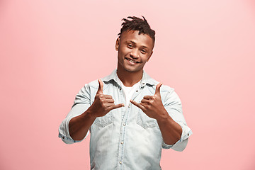 Image showing The happy business man standing and smiling against pink background.