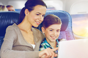 Image showing happy family with tablet pc sitting in plane