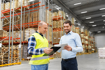 Image showing worker and businessman with tablet pc at warehouse