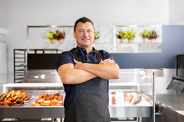 Image showing male seller with seafood at fish shop fridge