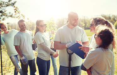 Image showing group of volunteers with tree seedlings in park