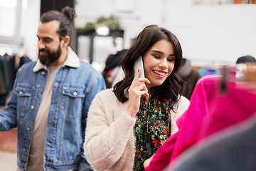 Image showing woman calling on smartphone at clothing store