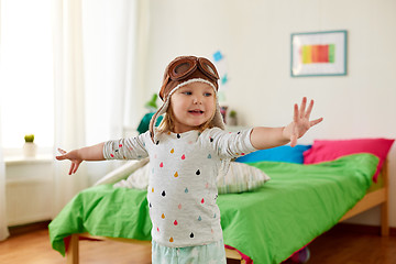 Image showing happy little girl in pilot hat playing at home