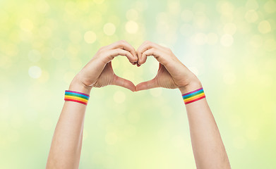 Image showing male hands with gay pride wristbands showing heart