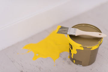 Image showing Yellow paint tin can with brush on top