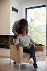 Image showing multiethnic couple hugging in front of fireplace