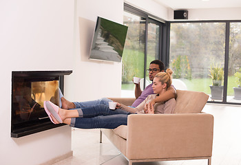 Image showing Young multiethnic couple  in front of fireplace