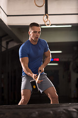 Image showing man workout with hammer and tractor tire