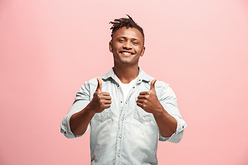 Image showing The happy business man standing and smiling against pink background.
