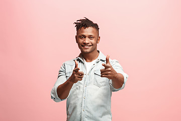 Image showing The happy business man standing and smiling against pink background.