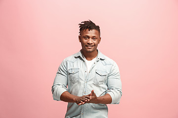 Image showing The happy business man standing and smiling against pink background.