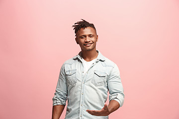 Image showing The happy business man standing and smiling against pink background.