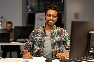 Image showing creative man with tablet pc at night office