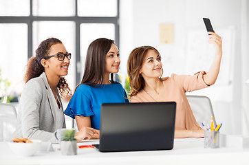 Image showing happy businesswomen taking selfie at office