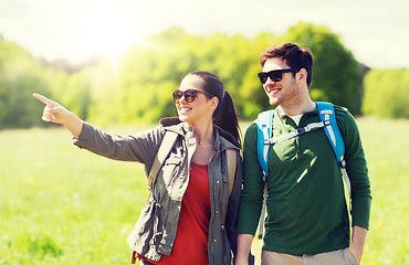 Image showing happy couple with backpacks hiking outdoors