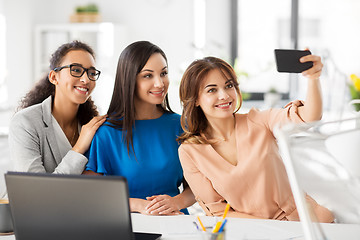Image showing happy businesswomen taking selfie at office
