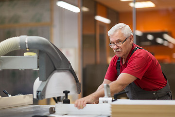 Image showing carpenter with panel saw and fibreboard at factory