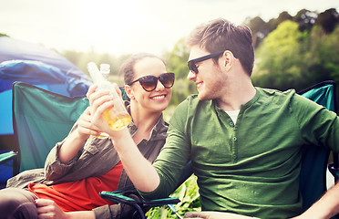 Image showing happy couple clinking drinks at campsite tent