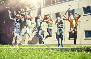 Image showing happy teenage students or friends jumping outdoors