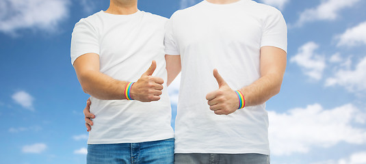 Image showing gay couple with rainbow wristbands shows thumbs up