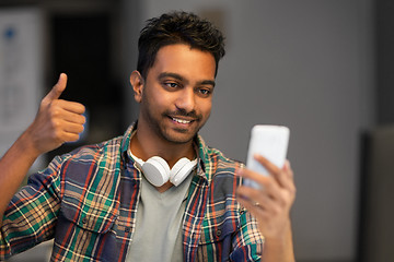 Image showing man with smartphone having video call at office