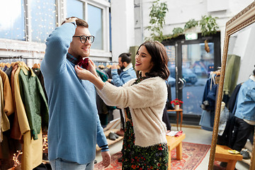 Image showing couple choosing bowtie at vintage clothing store