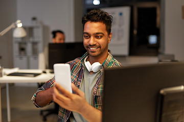 Image showing man with smartphone having video call at office