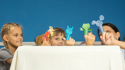 Image showing Mom and daughters show a performance in a fingered self-made puppet theater