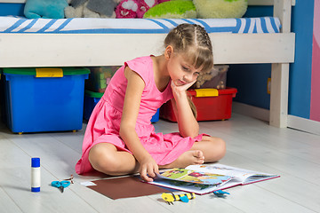 Image showing The girl with interest leafs through the book of creativity