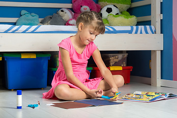 Image showing Girl is making out of colored paper figurines