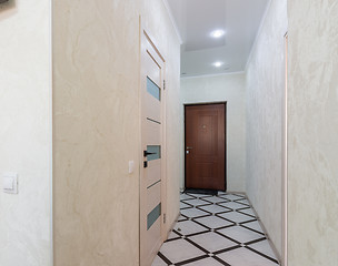 Image showing Long corridor in the apartment, closed door to the bathroom