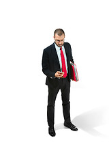 Image showing Serious businessman wiht mobile phone with folder in hand isolated over white background in studio