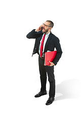 Image showing Happy businessman talking on the phone with folder in hand isolated over white background in studio