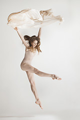 Image showing Young beautiful dancer in beige swimsuit dancing on gray background