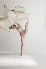 Image showing Young beautiful dancer in beige swimsuit dancing on gray background