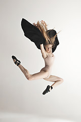 Image showing Young beautiful dancer in beige swimsuit dancing on gray background