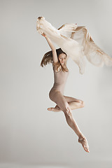 Image showing Young beautiful dancer in beige swimsuit dancing on gray background