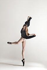 Image showing Young beautiful dancer in beige swimsuit dancing on gray background