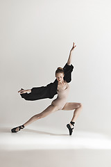 Image showing Young beautiful dancer in beige swimsuit dancing on gray background