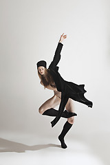 Image showing Young beautiful dancer in beige swimsuit dancing on gray background