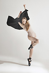 Image showing Young beautiful dancer in beige swimsuit dancing on gray background