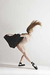 Image showing Young beautiful dancer in beige swimsuit dancing on gray background