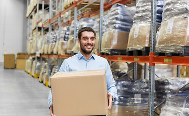 Image showing happy man with cardboard parcel box at warehouse