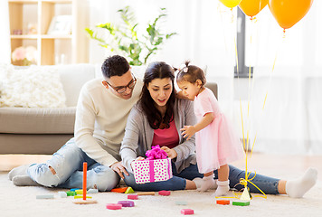 Image showing baby girl with birthday gift and parents at home 