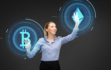 Image showing businesswoman with cryptocurrency holograms