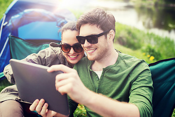 Image showing happy couple with tablet pc at camping tent